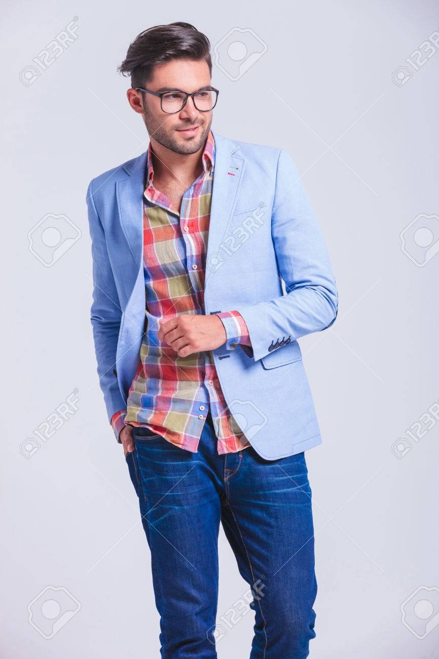 attractive fashionable man wearing glasses walking in studio background with hand in back pocket while looking away from the camera - 52314637 attractive fashionable man wearing glasses walking in studio background with hand in back pocket while looking away from the camera - 52314637