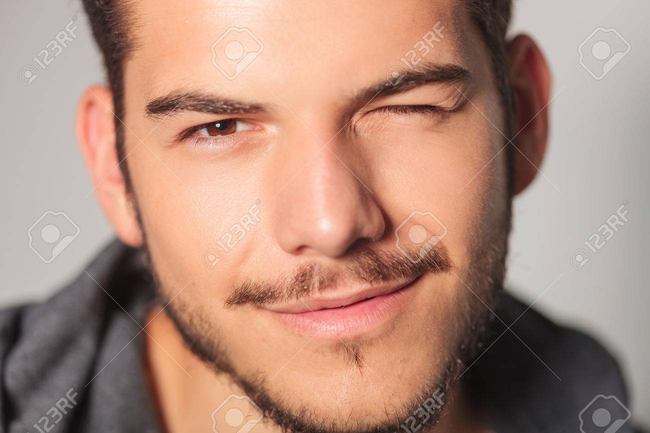 Smilling Young Man Is Winking His Eye , Closeup Picture In Studio Stock  Photo, Picture and Royalty Free Image. Image 64558605., image size:1300x866