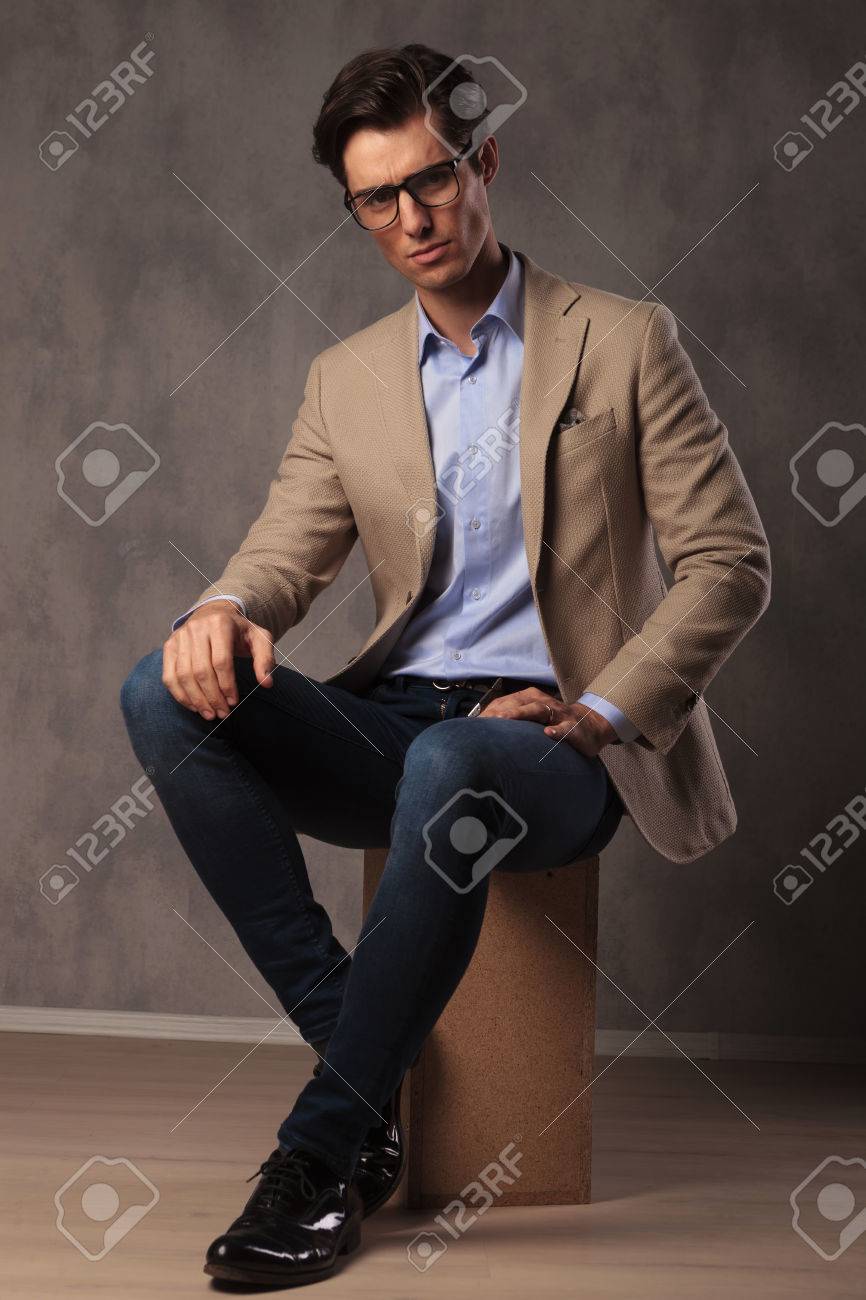 Homme élégant Cool Assis En Studio, Portant Un Jean Et Un Homme élégant Cool Assis En Studio, Portant Un Jean Et Un