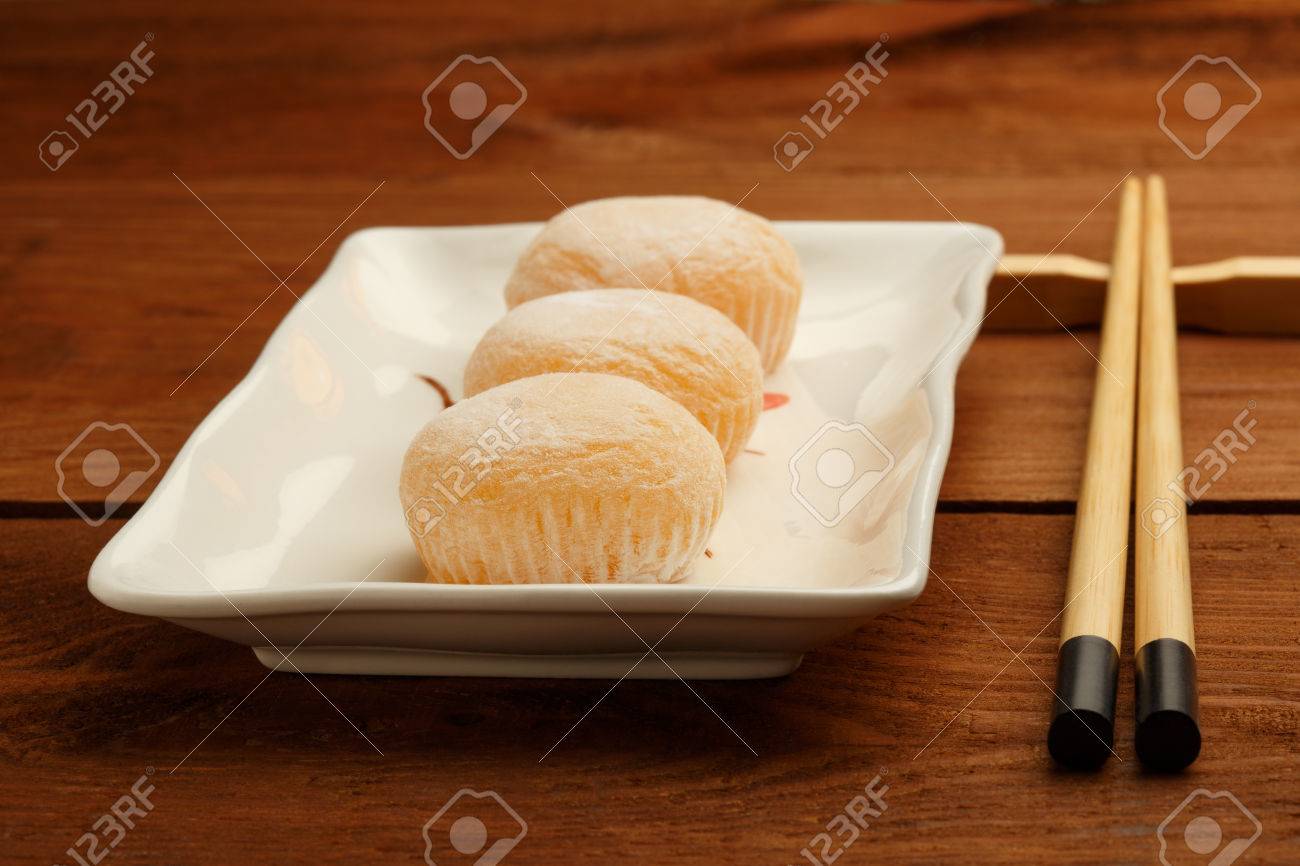 Three delicious japanese mochi rice cakes on white plate standing..