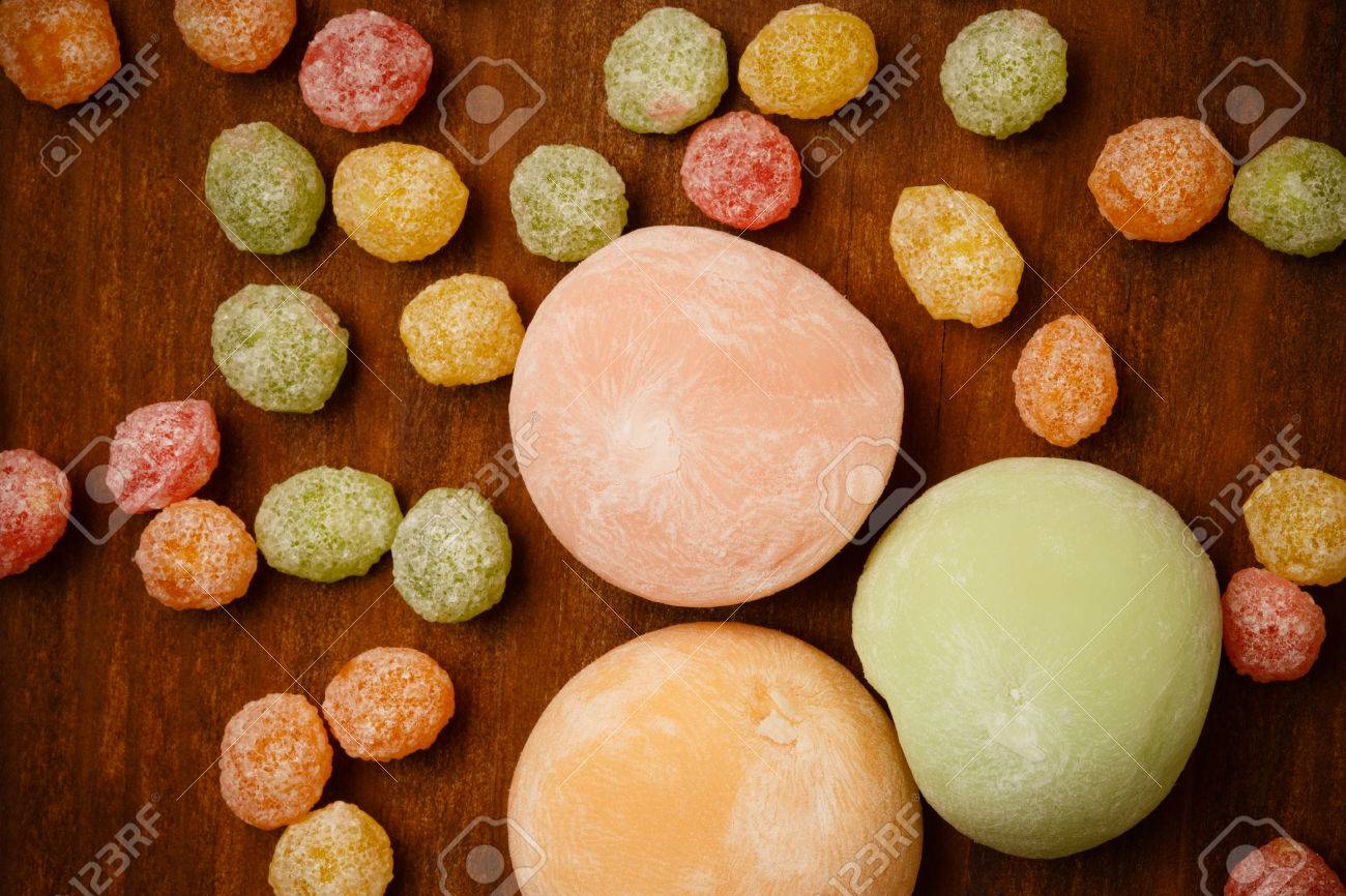 Beautiful colorful japanese mochi rice cakes lying on brown wooden..