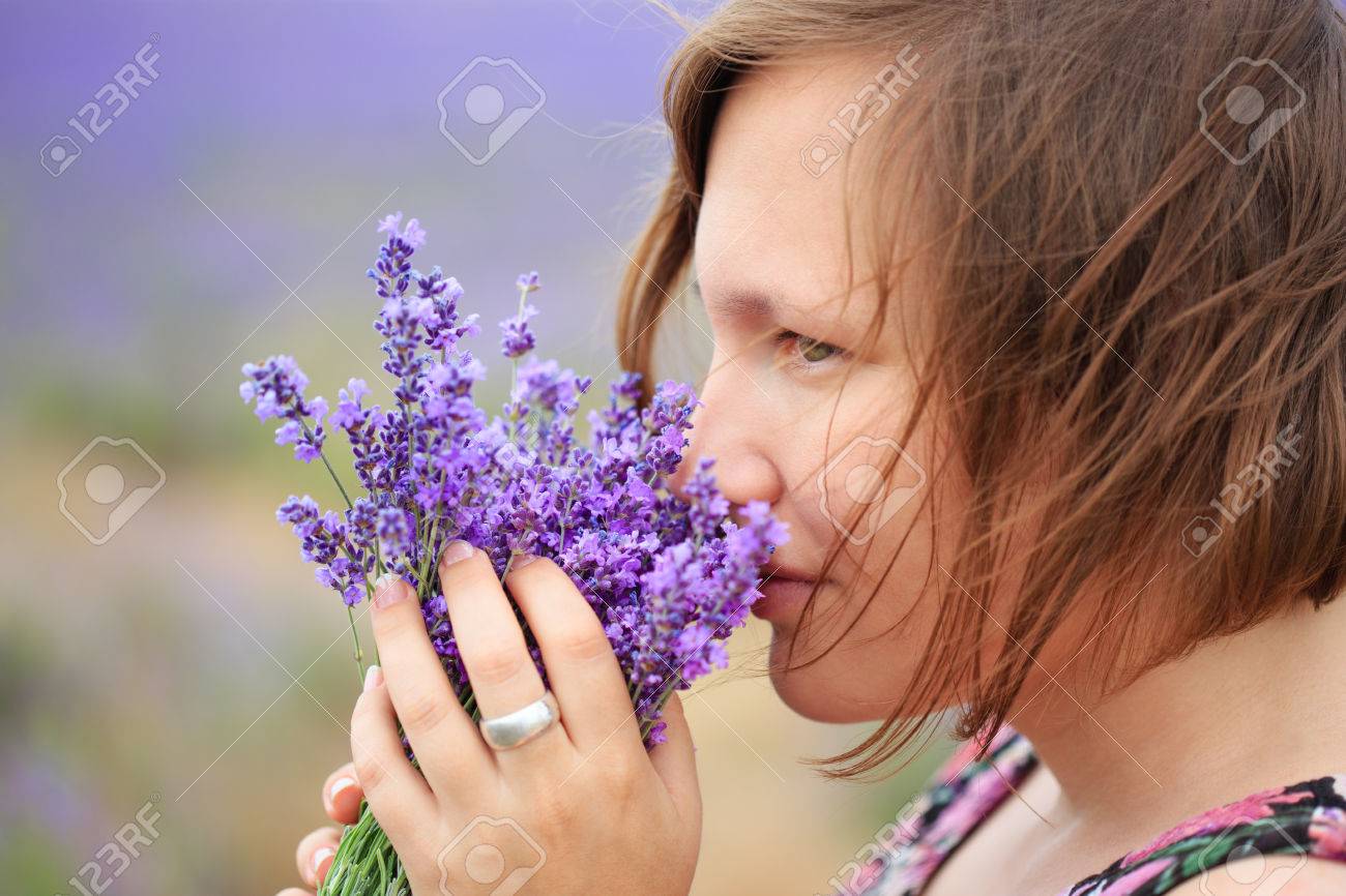 ライラック ラベンダーの花の香りと美しい思いやりのある若い女性はぼやけているラベンダー畑の背景に花柄立ってブラウスに身を包んだ の写真素材 画像素材 Image