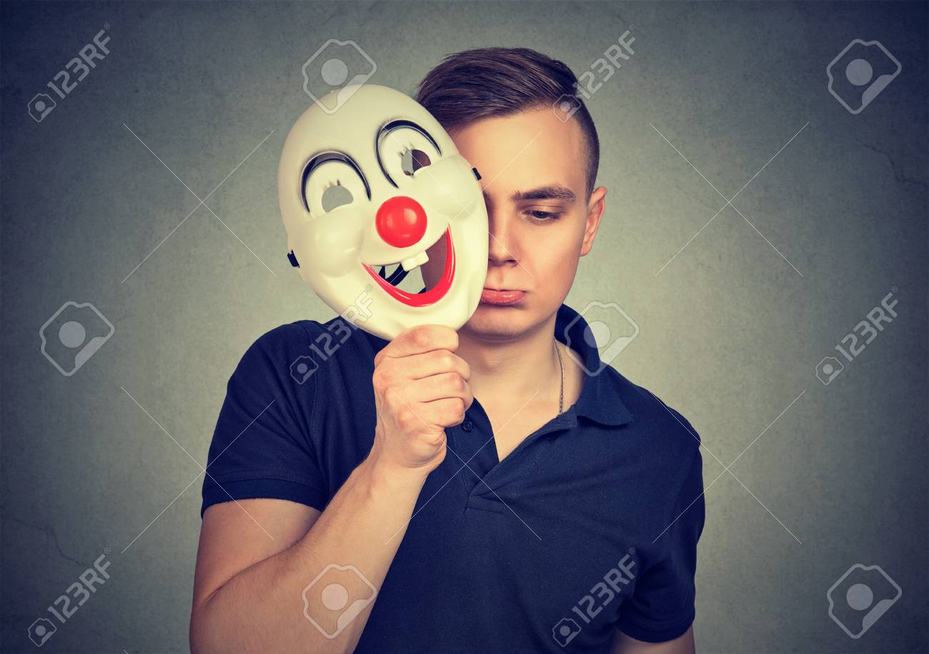 Sad And Depressed Man Covering Face With Happy Clown Mask Hiding Stock Photo Picture And Royalty Free Image Image 108031341