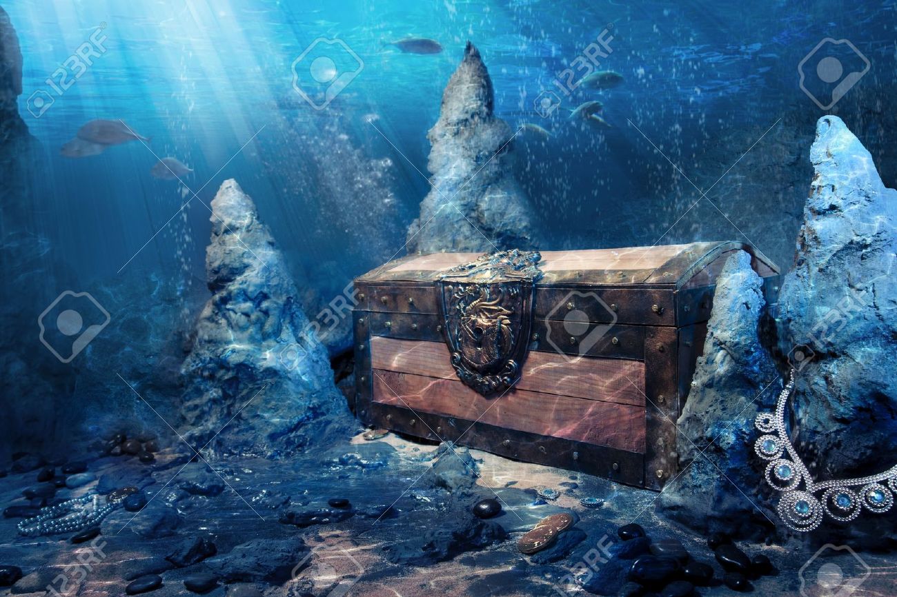 photo of wooden treasure chest submerged underwater with light