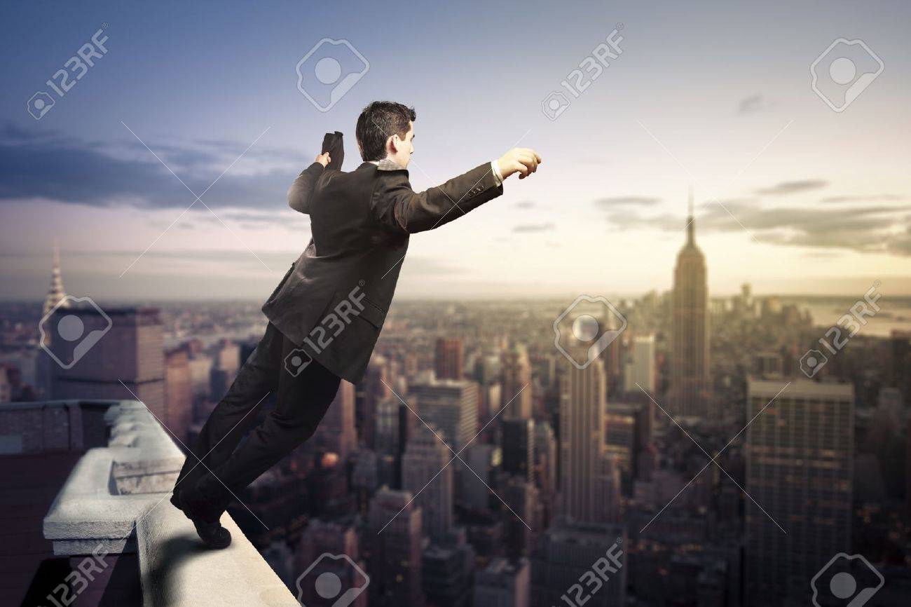 troubled businessman jumping from the top of a building stock photo