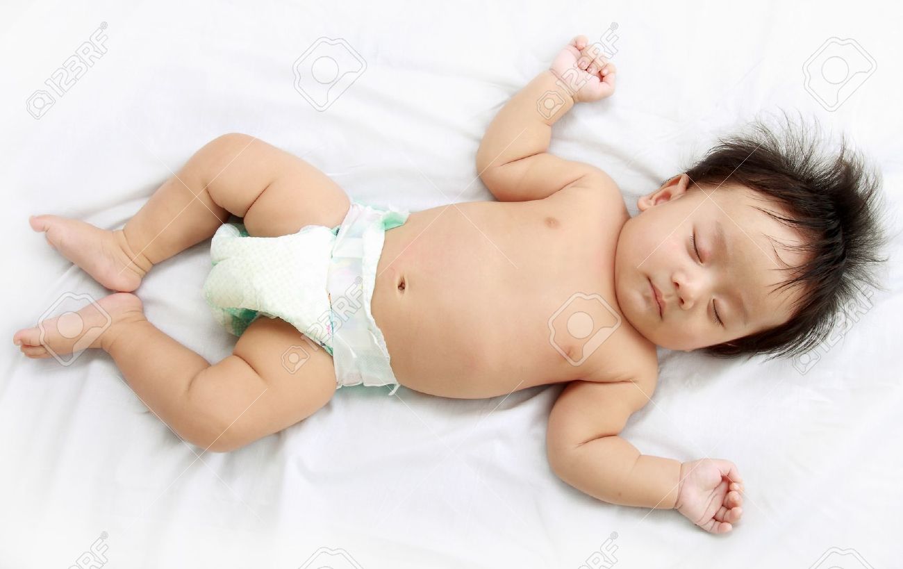 close up of adorable little baby laying in the bed stock photo