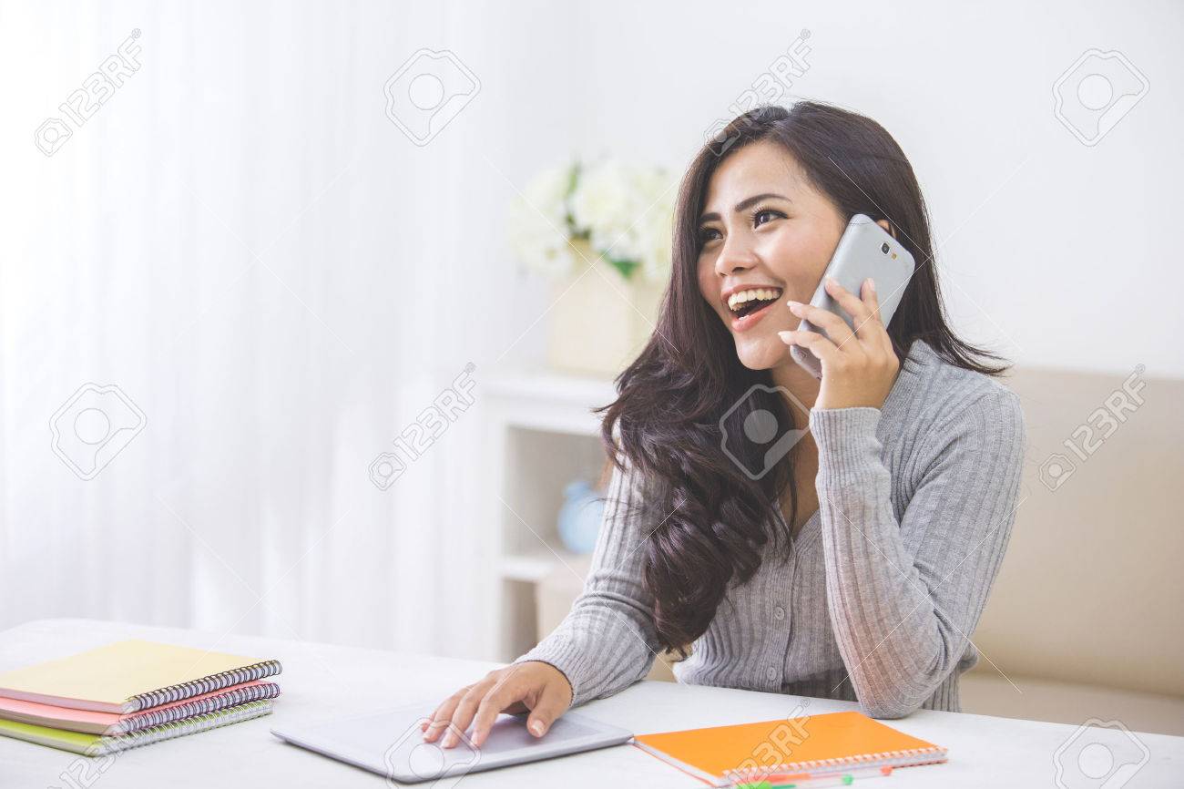 portrait of casual asian woman making a phone call at home using smart phone - 53376192 portrait of casual asian woman making a phone call at home using smart phone - 53376192