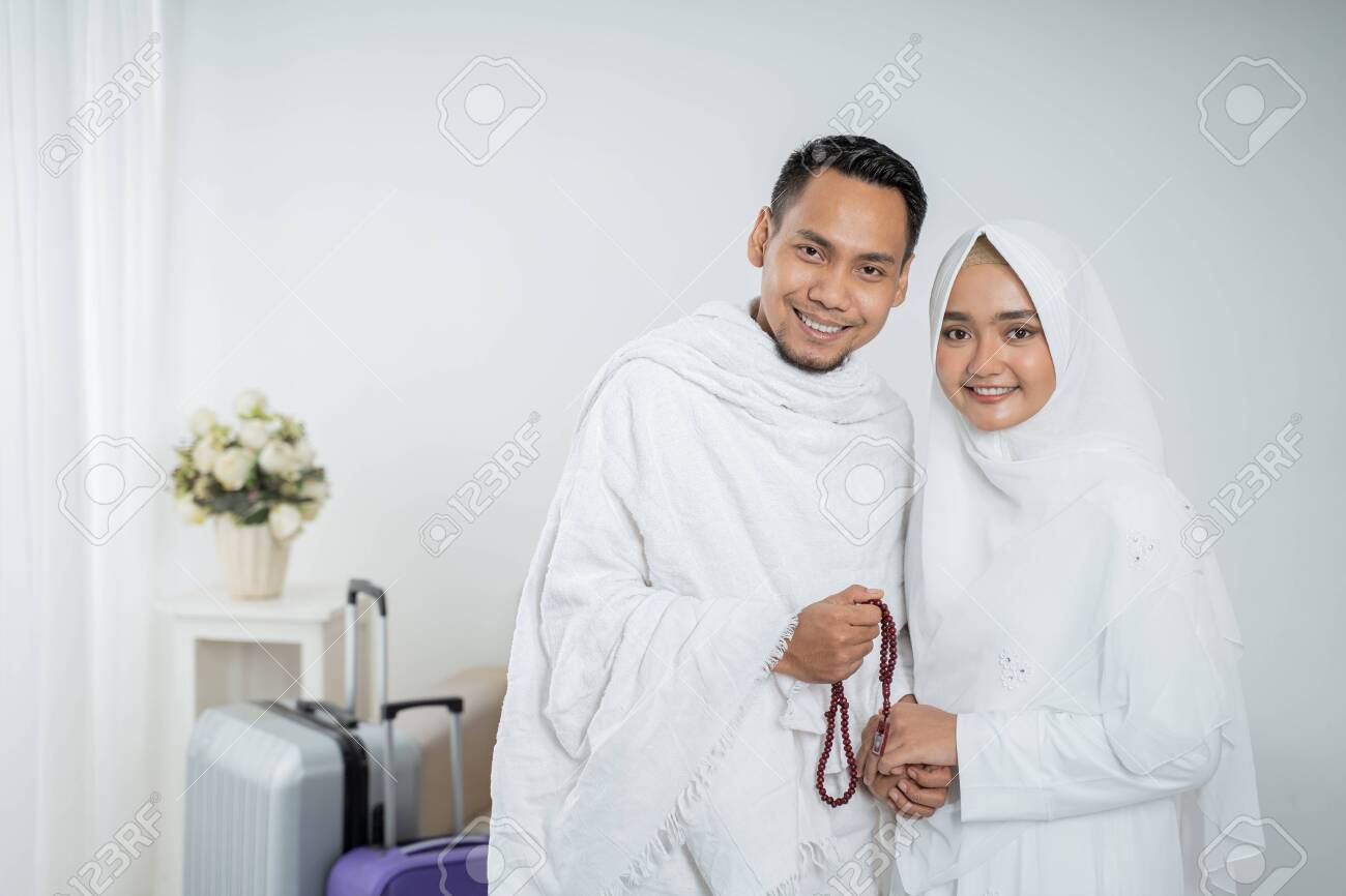 muslim pilgrims wife and husband in white traditional clothes - 128191523 muslim pilgrims wife and husband in white traditional clothes - 128191523