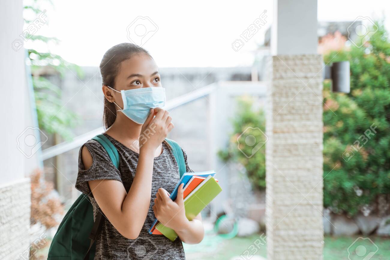 Asian student girl wears a mask with backpack take away books - 153667437 Asian student girl wears a mask with backpack take away books - 153667437