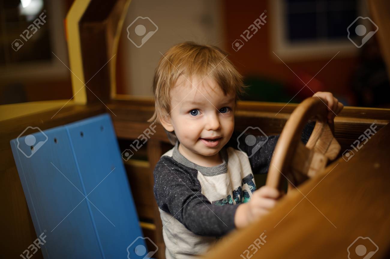 Mignon Petit Garcon Joue Dans Une Grosse Voiture En Bois Jouet A La Salle De Jeux Banque D Images Et Photos Libres De Droits Image