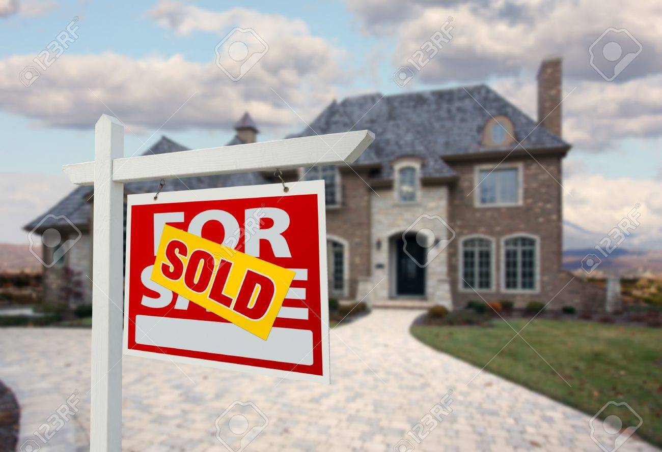 sold home for sale sign in front of beautiful new house for sale sign sold