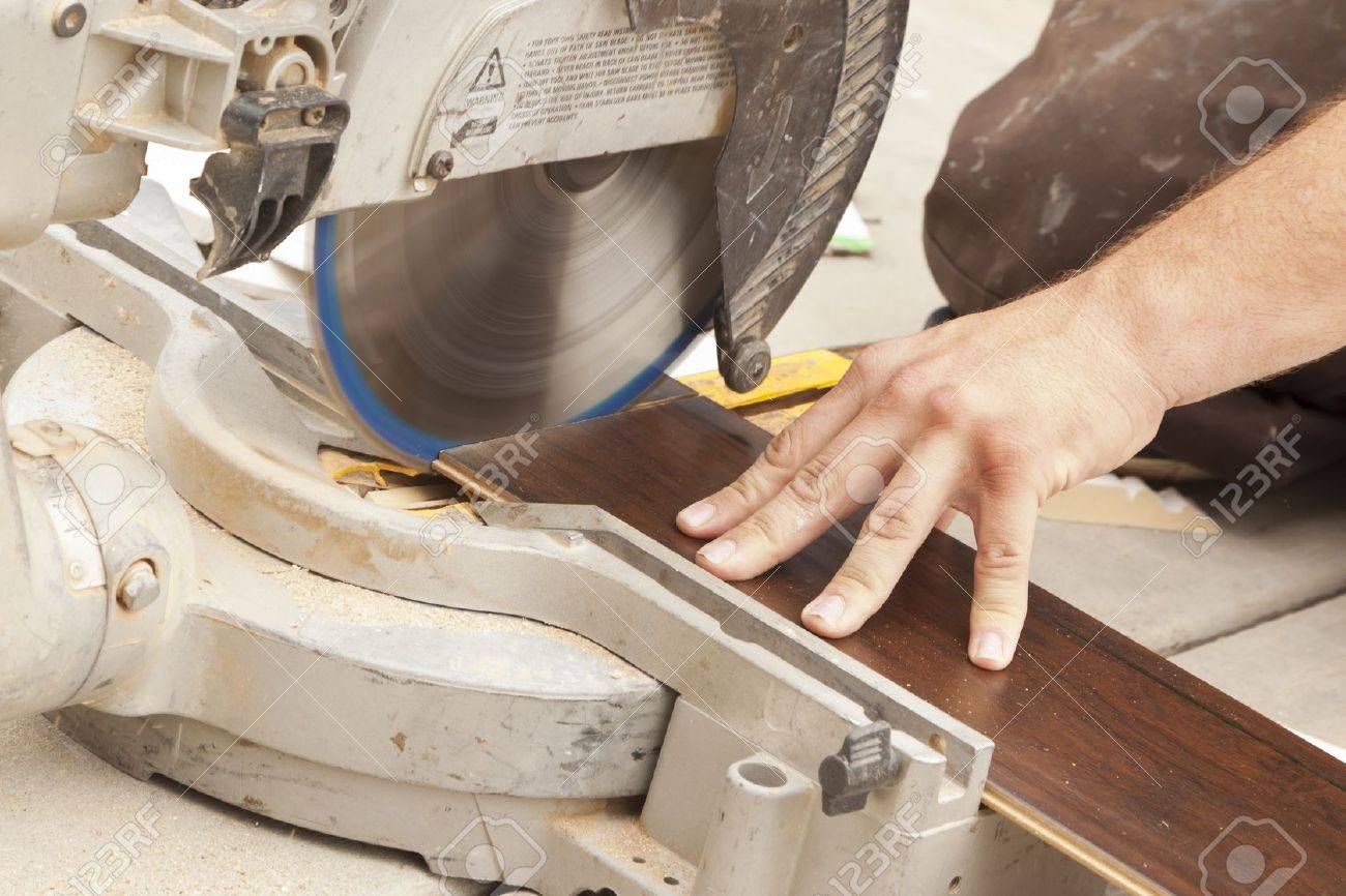 Contractor Using Circular Saw Cutting Of New Laminate Flooring
