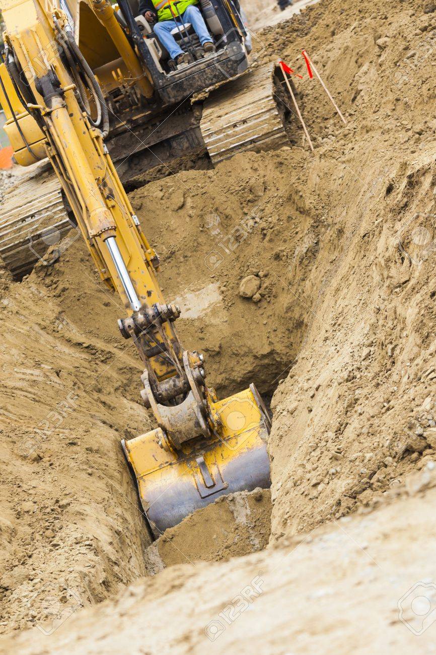 working excavator tractor digging a trench stock photo picture and