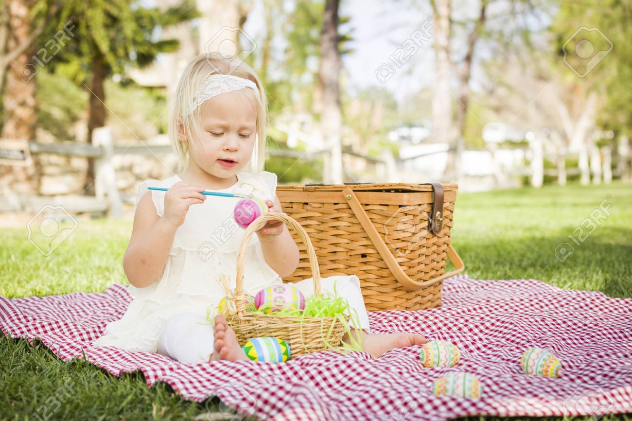 Cute Baby Girl Enjoys Coloring Her Easter Eggs On Picnic Blanket In The Grass Stock Photo Picture And Royalty Free Image Image
