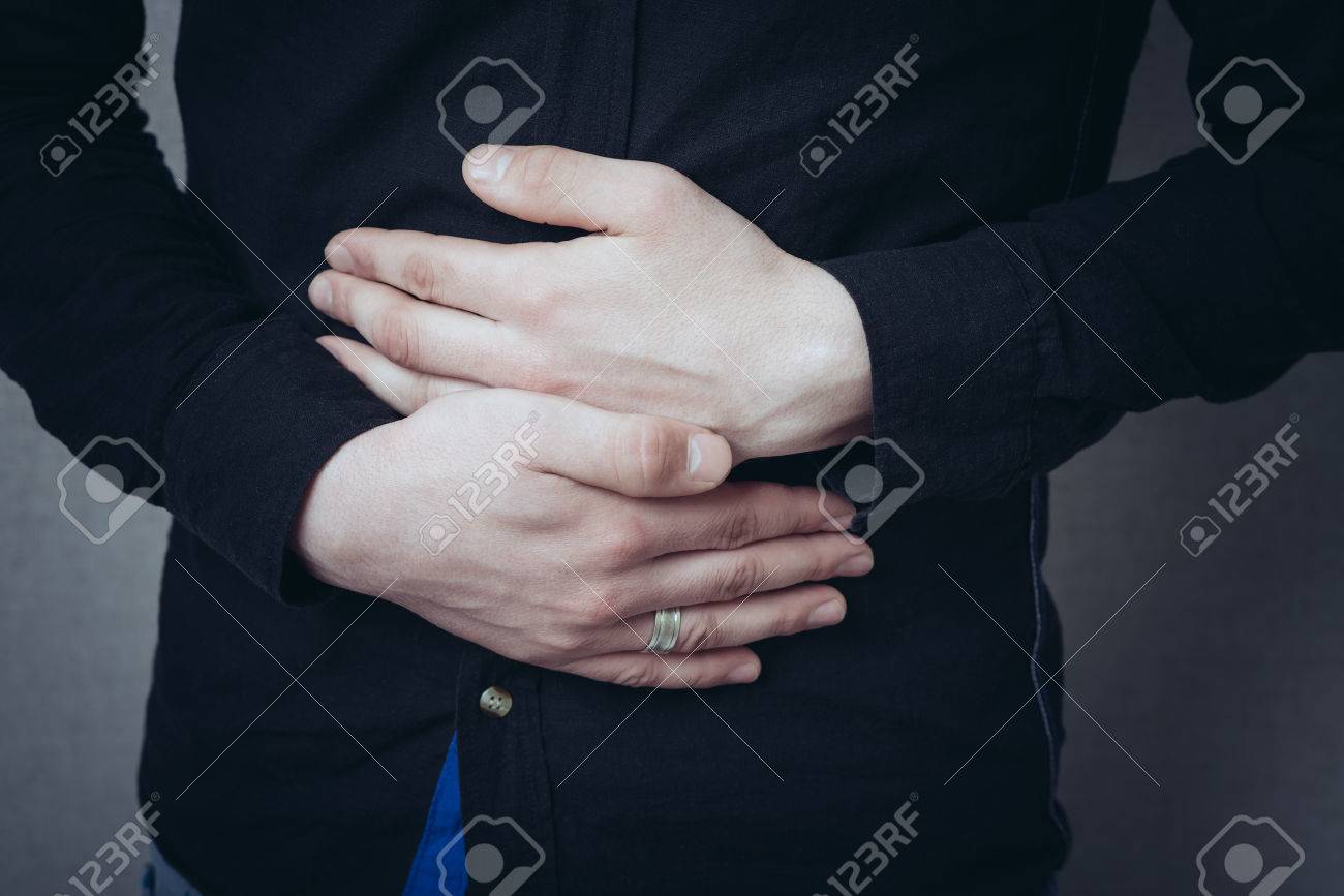 Man hands on his stomach, stomach ache. Gesture stomach ache, cramps. On a gray background - 42327638 Man hands on his stomach, stomach ache. Gesture stomach ache, cramps. On a gray background - 42327638