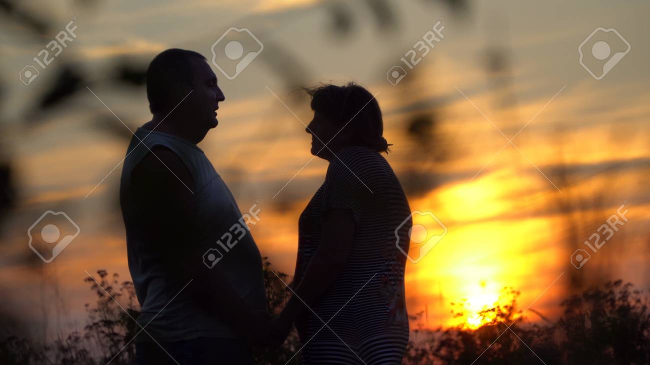 日没時に向かい合う男女 手をつないでキスする の写真素材 画像素材 Image