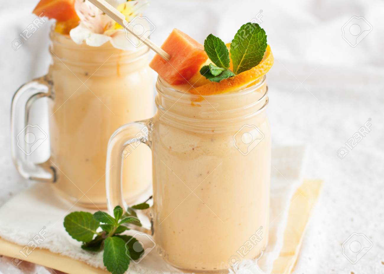 Homemade smoothie with tropical fruits: mango, banana, pineapple, papaya in glass Mason jar. Healthy juicy vitamin drink - 100767919 Homemade smoothie with tropical fruits: mango, banana, pineapple, papaya in glass Mason jar. Healthy juicy vitamin drink - 100767919