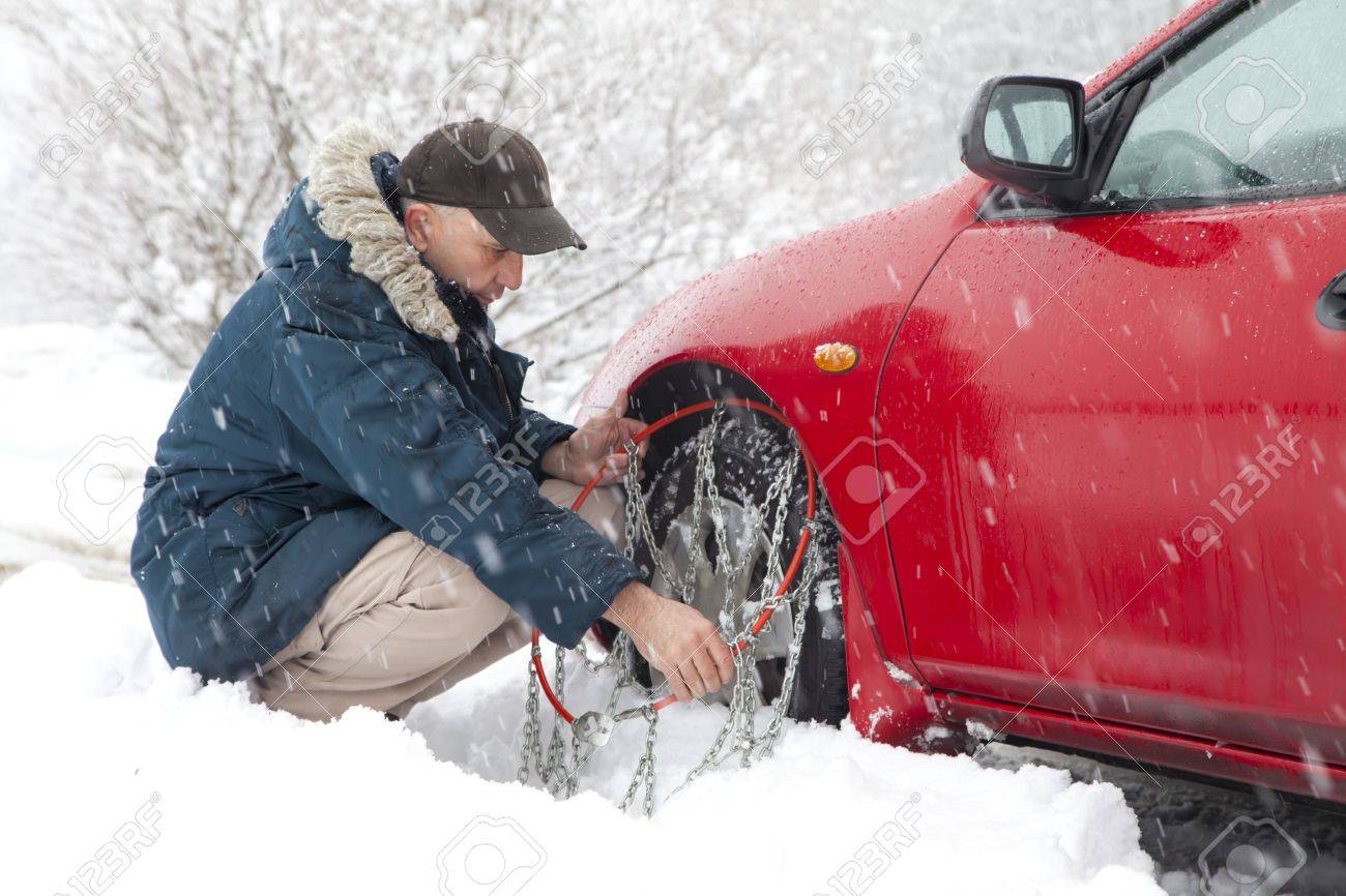 ミッド高齢男性ドライバーの車タイヤ チェーン雪道非常にマウント の写真素材 画像素材 Image