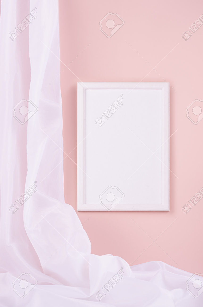 Delicate home decor with blank rectangle photo frame hanging on pastel pink wall, flow of silk curtain, vertical. Mock up for portfolio, design or text. - 168468876 Delicate home decor with blank rectangle photo frame hanging on pastel pink wall, flow of silk curtain, vertical. Mock up for portfolio, design or text. - 168468876