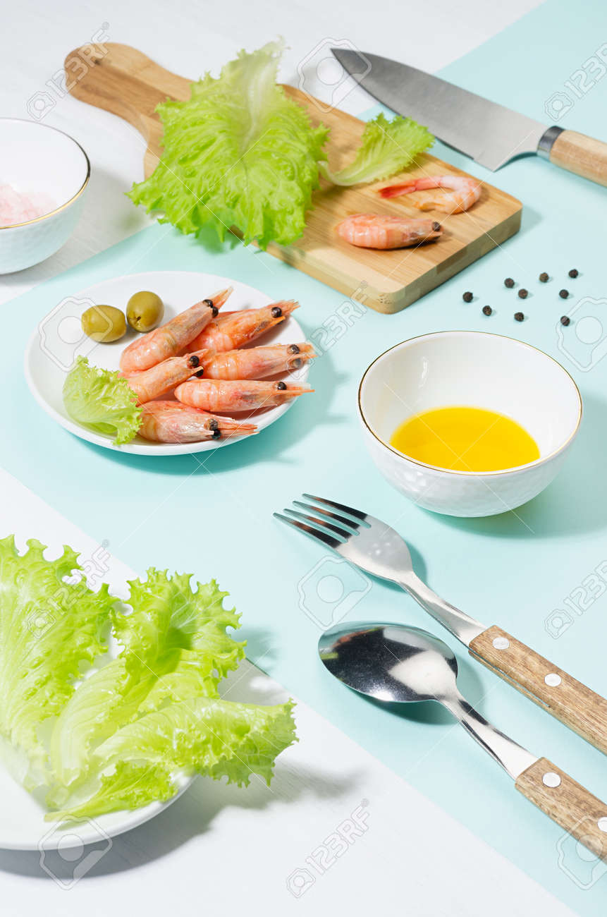 Dieting salad of fresh greens, shrimps with shadow in hard light on pastel mint color and white wood table. Summer healthy food in color modern style. - 168468920 Dieting salad of fresh greens, shrimps with shadow in hard light on pastel mint color and white wood table. Summer healthy food in color modern style. - 168468920
