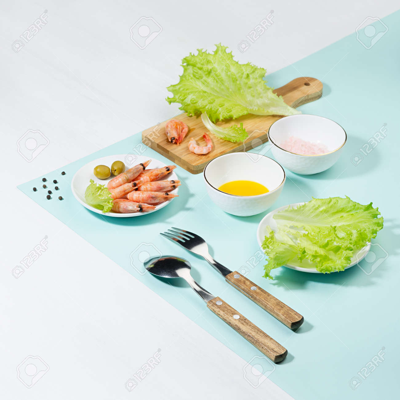 Dieting salad of fresh greens, shrimps with shadow in hard light on pastel mint color and white wood table, square. Summer healthy food in color modern style. - 168468974 Dieting salad of fresh greens, shrimps with shadow in hard light on pastel mint color and white wood table, square. Summer healthy food in color modern style. - 168468974