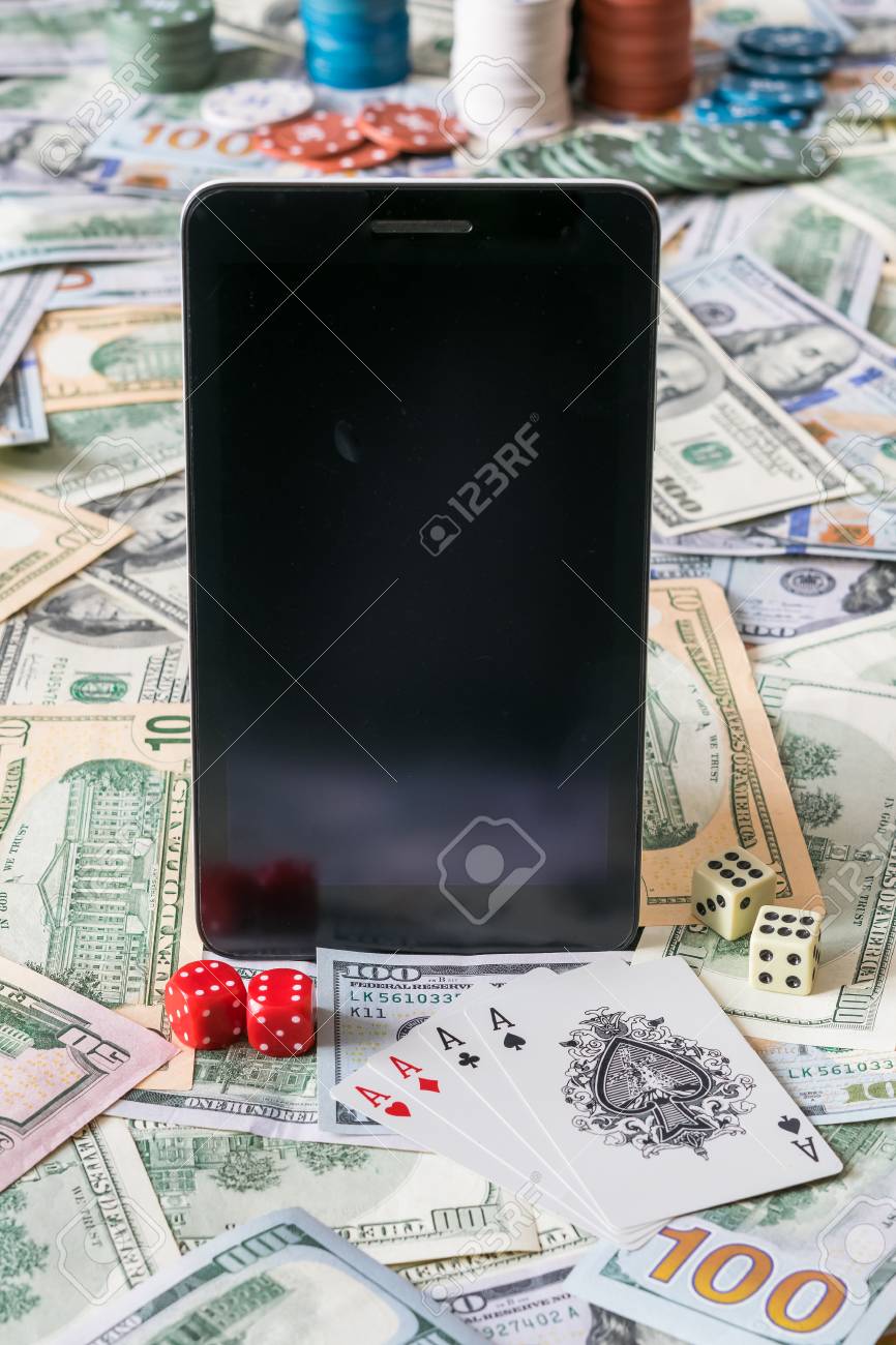 携帯カジノの背景。火かき棒カード、チップ、サイコロ、現金とタブレット。コンセプトは、選択と集中をギャンブルの写真素材・画像素材 Image  73522153