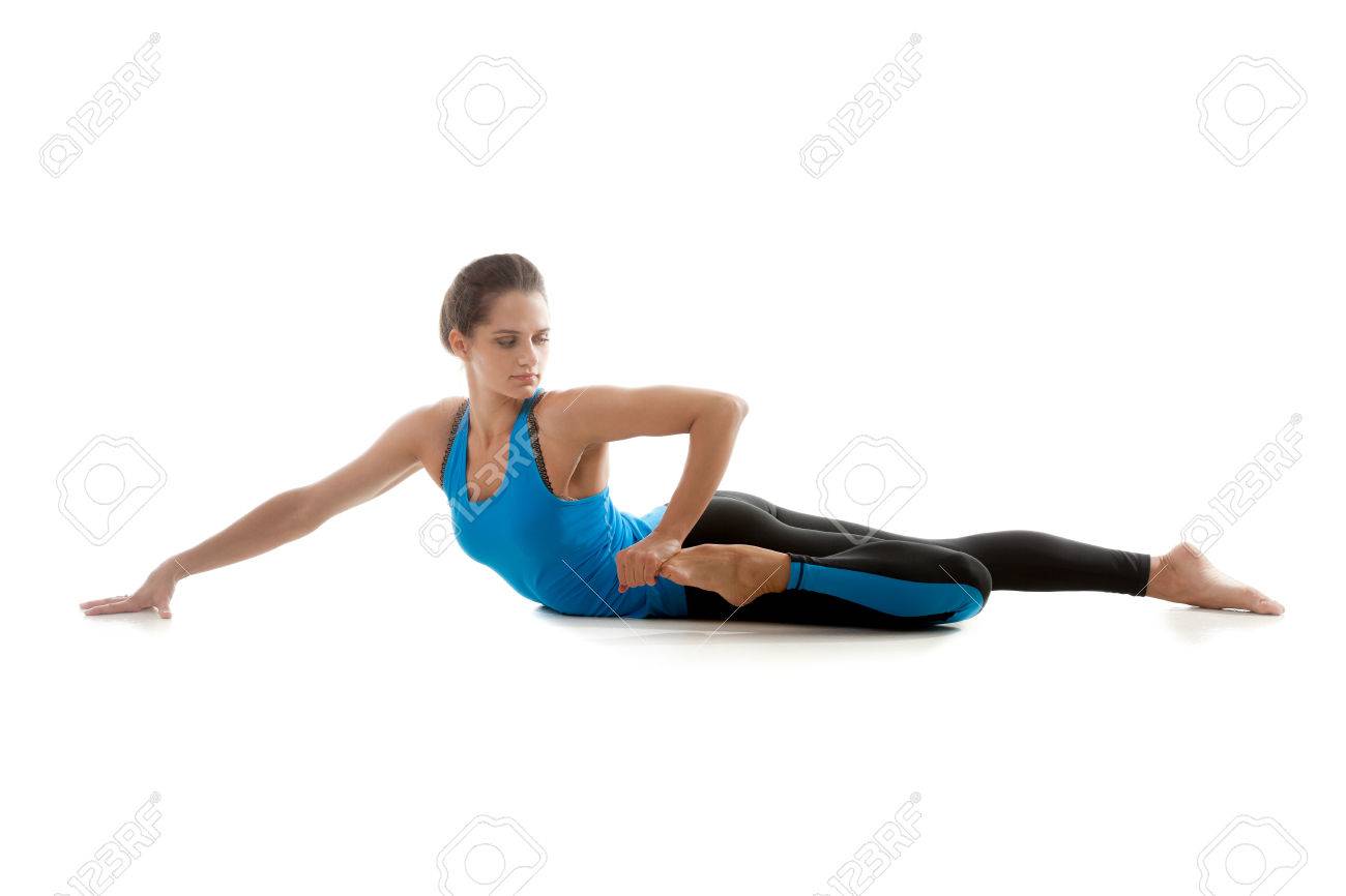 白い背景と彼女の足の筋肉のストレッチのスポーティなヨガの女の子 の
