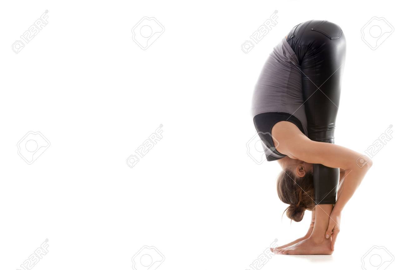 Sporty Yoga Girl On White Background In Uttanasana Intense Forward Bending Pose Sporty Yoga Girl On White Background In Uttanasana Intense Forward Bending Pose