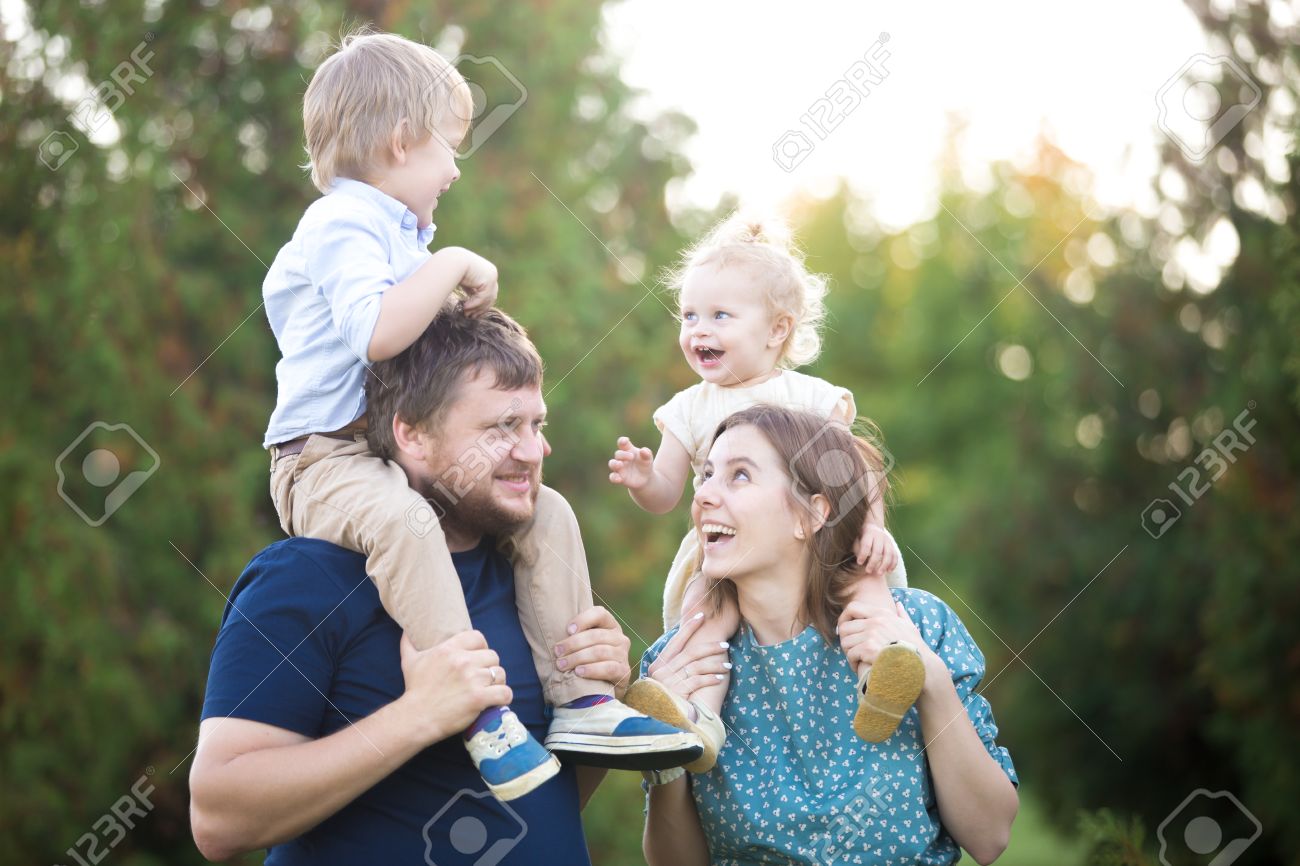 夏に公園を歩いて 4 つの幸せな美しい家族の肖像画 ママとパパの肩に 2 つ小さな陽気な笑っている子供たちを運ぶします 両親と兄弟プレイ 一緒に楽しんで の写真素材 画像素材 Image 46169359