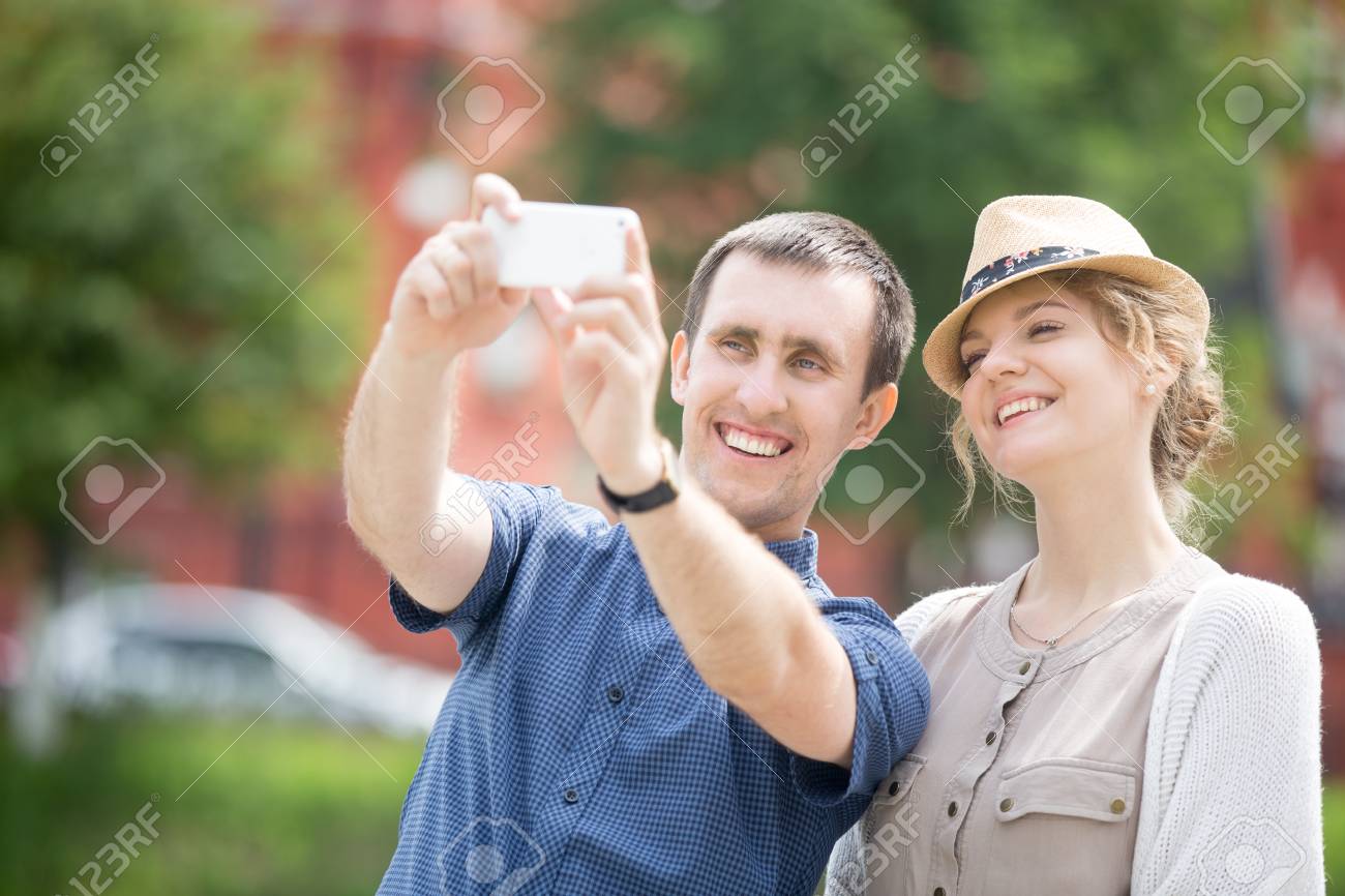 スマート フォンで海外旅行中に Selfie を作る幸せな美しい方カップルの肖像画 魅力的な若い女の子と海外旅行の観光中に写真を撮る男旅 の写真素材 画像素材 Image
