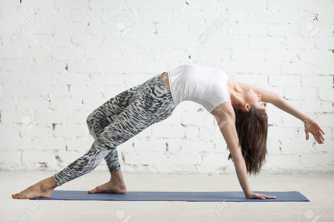 Young attractive woman practicing yoga, doing Wild Thing, Flip-the-Dog.. Young attractive woman practicing yoga, doing Wild Thing, Flip-the-Dog..