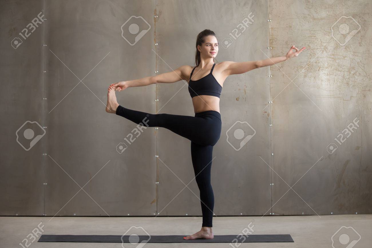 Young woman practicing yoga, standing in Parivrtta Utthita Hasta.. Young woman practicing yoga, standing in Parivrtta Utthita Hasta..