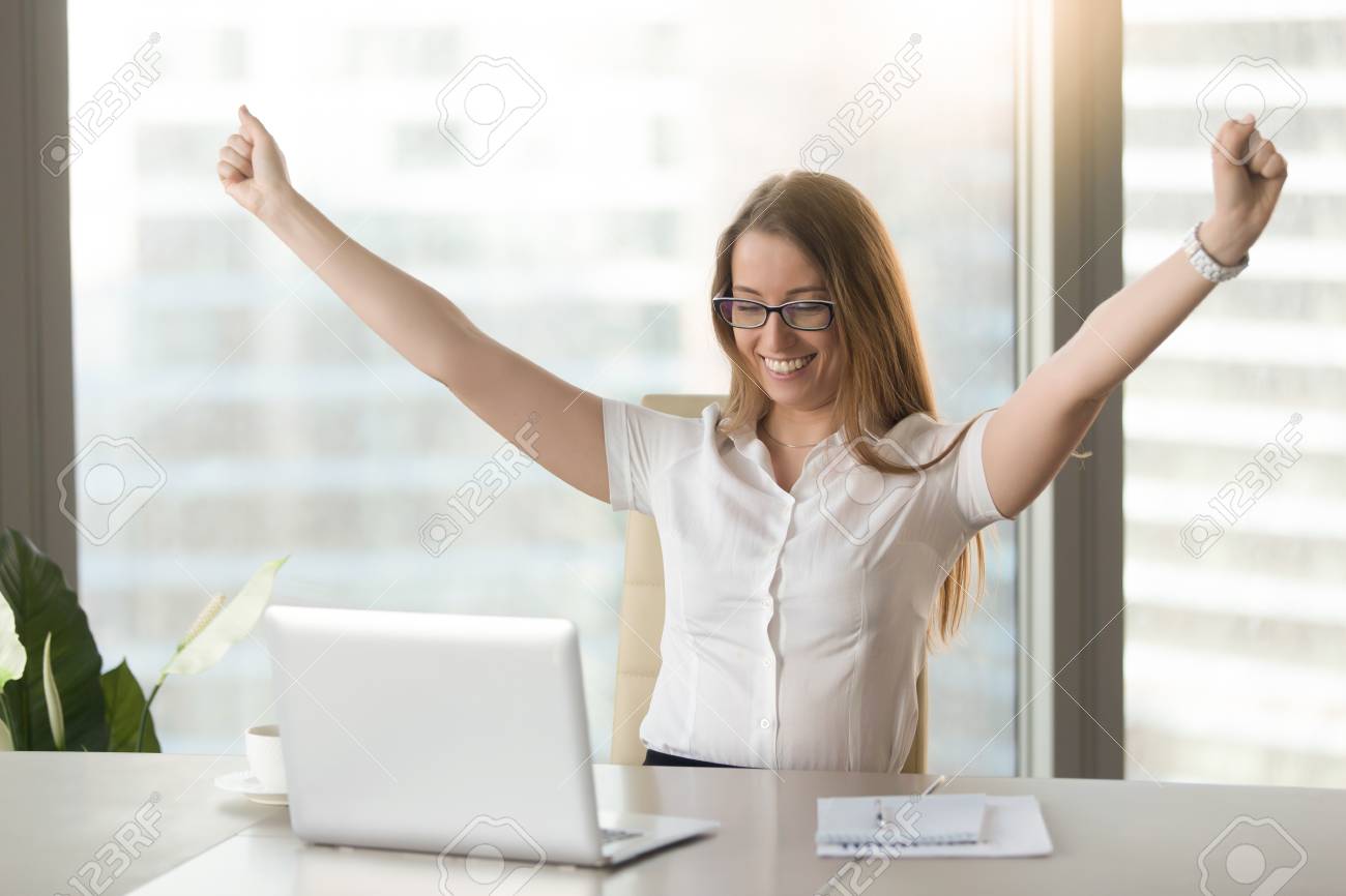 Excited smiling businesswoman celebrating business success at workplace, raising hands looking at laptop screen, feeling happy about great win, good news online, positive result, passed exam, got job - 86667378 Excited smiling businesswoman celebrating business success at workplace, raising hands looking at laptop screen, feeling happy about great win, good news online, positive result, passed exam, got job - 86667378