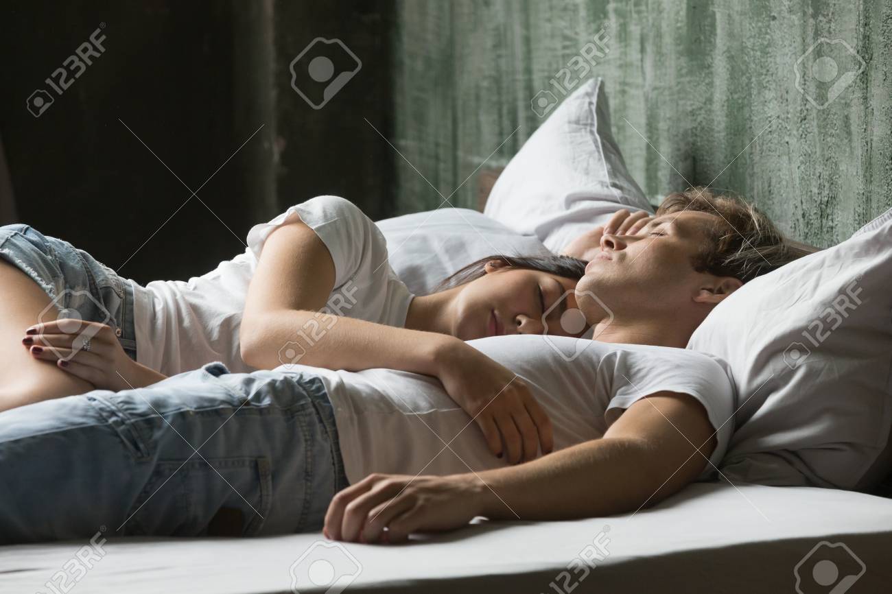 昼寝のコンセプトを持つ若いカップル ボーイフレンドとガールフレンドの睡眠愛好家は 一緒にベッドに横たわって昼間に眠って楽しんで 男女は寝室で眠っている眠りに抱いて眠りに落ちる の写真素材 画像素材 Image