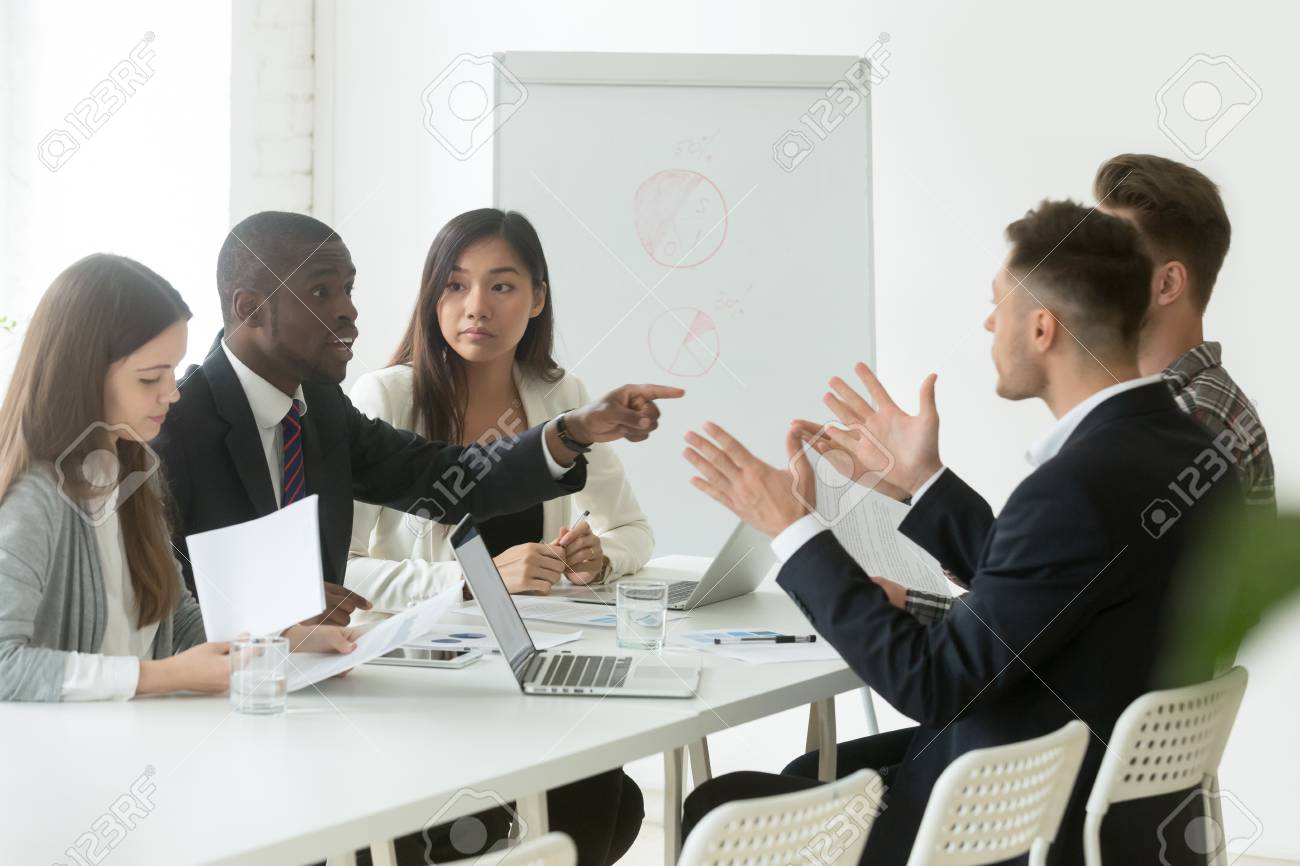 Diverse employees arguing during team meeting, african office worker disagreeing with caucasian colleague - 101473201 Diverse employees arguing during team meeting, african office worker disagreeing with caucasian colleague - 101473201