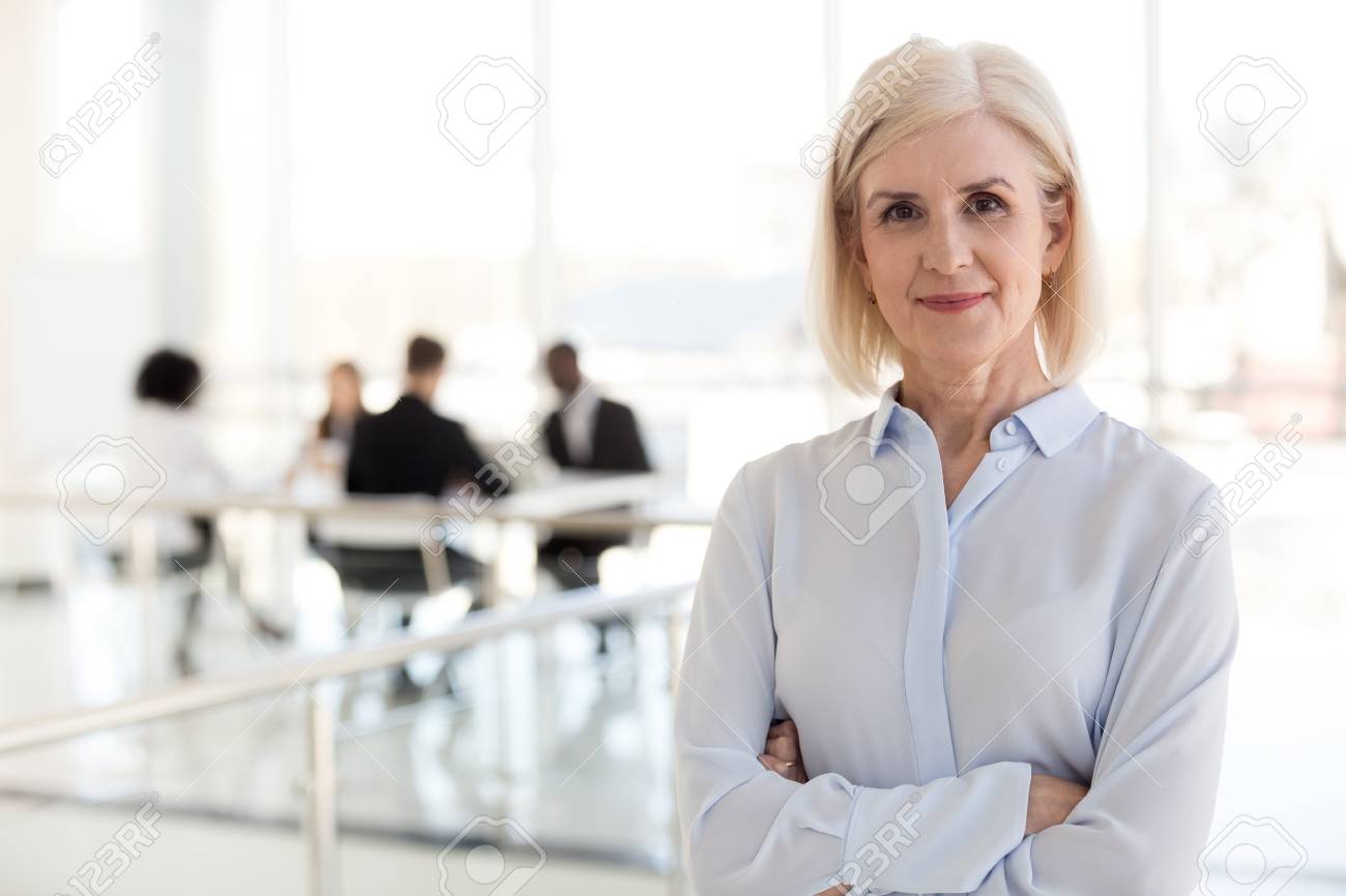 Confident mature businesswoman looking at camera, middle aged company ceo director, experienced senior female professional, old lady business coach team leader posing in office, headshot portrait - 112485480 Confident mature businesswoman looking at camera, middle aged company ceo director, experienced senior female professional, old lady business coach team leader posing in office, headshot portrait - 112485480