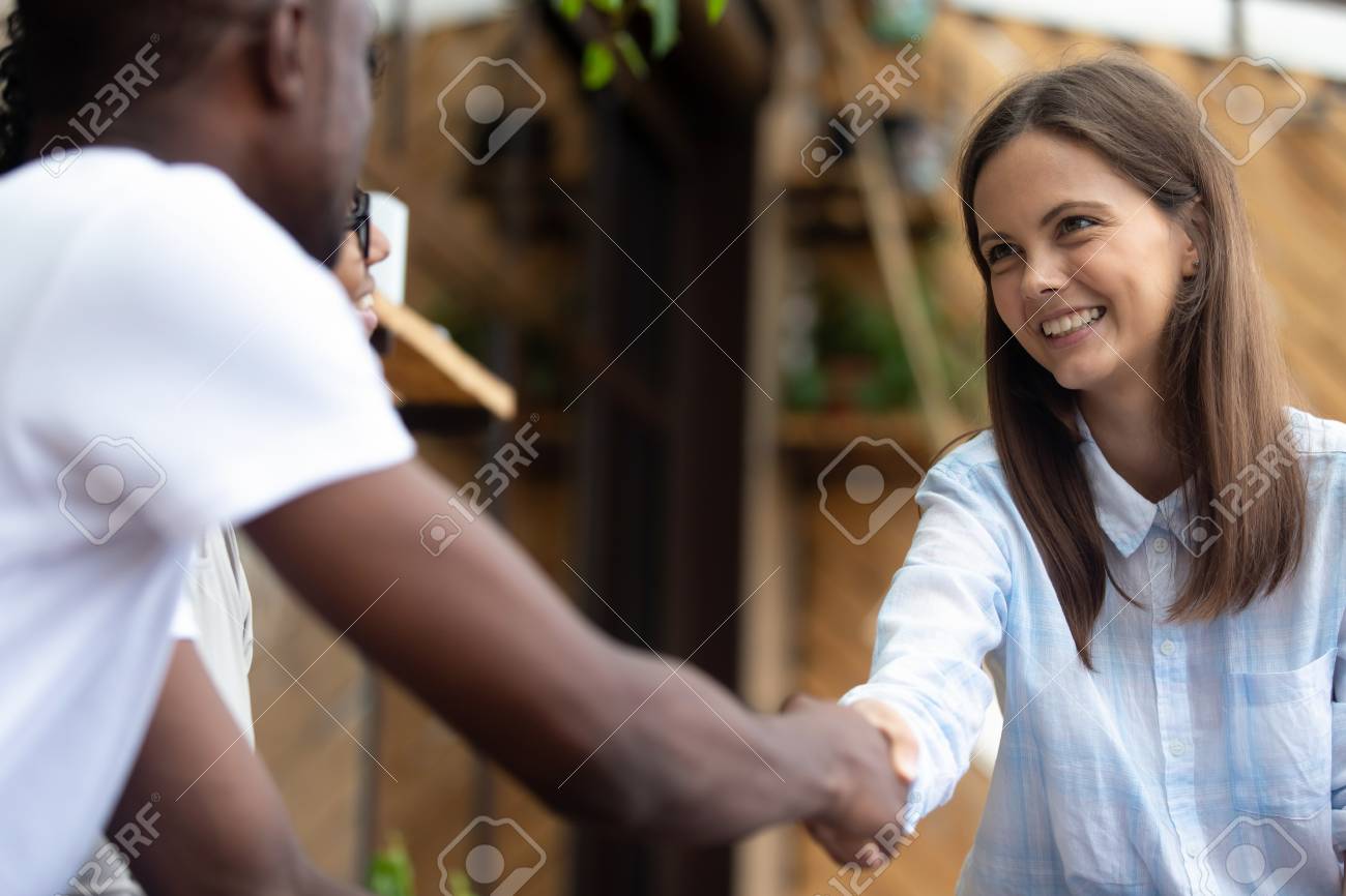 African American Man Shaking Hand Of Smiling Woman Close Up