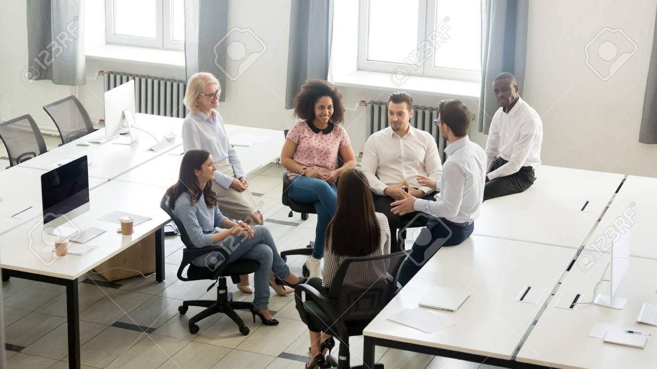 Male manager coach mentor speaking at corporate group business meeting, team leader talking to workers training interns at workshop explaining new project strategy in office, top view overhead above - 120519812 Male manager coach mentor speaking at corporate group business meeting, team leader talking to workers training interns at workshop explaining new project strategy in office, top view overhead above - 120519812