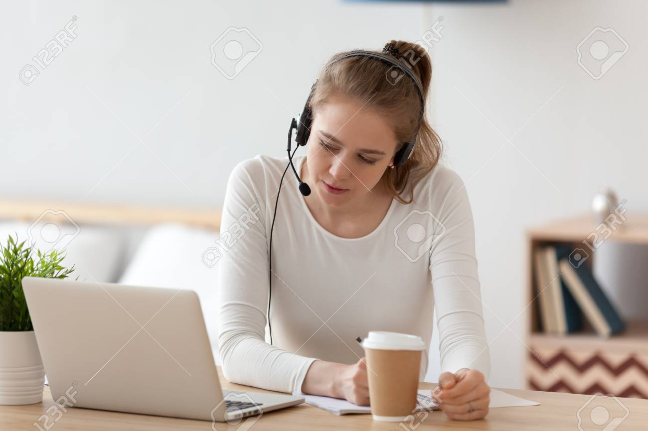 Focused woman in headset using laptop, looking at screen, studying online at home, distance learning language, writing notes, female student in headphones watching video seminar, webinar, - 120572649 Focused woman in headset using laptop, looking at screen, studying online at home, distance learning language, writing notes, female student in headphones watching video seminar, webinar, - 120572649