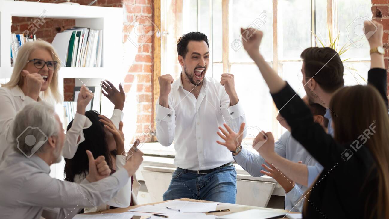 Euphoric excited business team celebrate corporate victory together in office, happy overjoyed professionals group rejoice company victory, teamwork success win triumph concept at conference table - 126490230 Euphoric excited business team celebrate corporate victory together in office, happy overjoyed professionals group rejoice company victory, teamwork success win triumph concept at conference table - 126490230