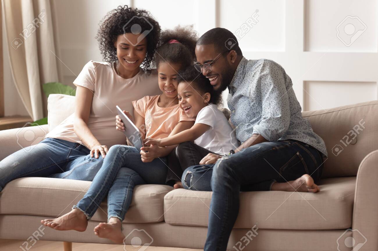 Happy African Family Having Fun With Device At Home, Black Parents And Little Children Using Digital Happy African Family Having Fun With Device At Home, Black Parents And Little Children Using Digital