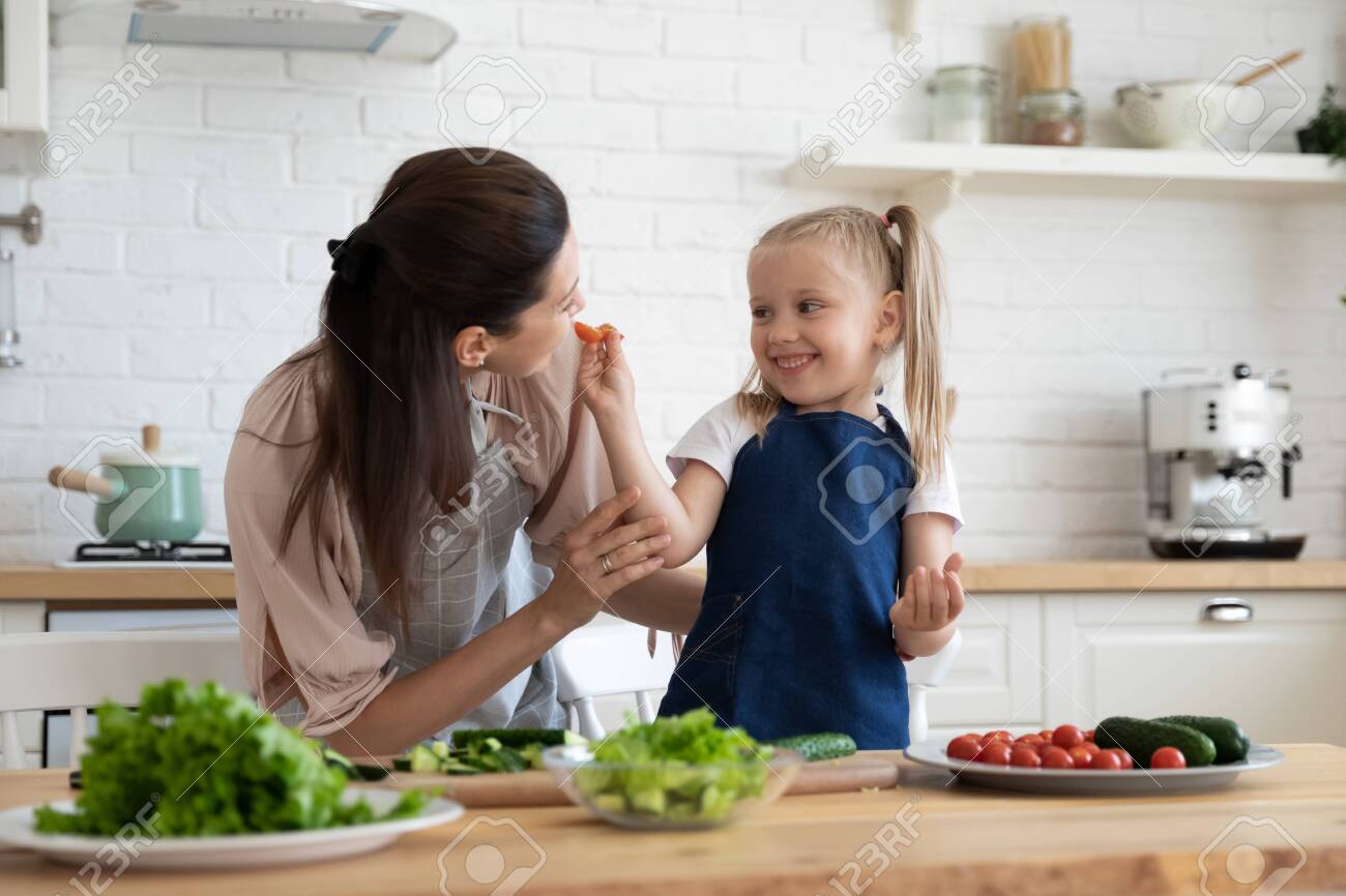 Little Daughter Learn To Cook Mother And Kid In Aprons Cooking Stock Photo Picture And Royalty Free Image Image 129468159