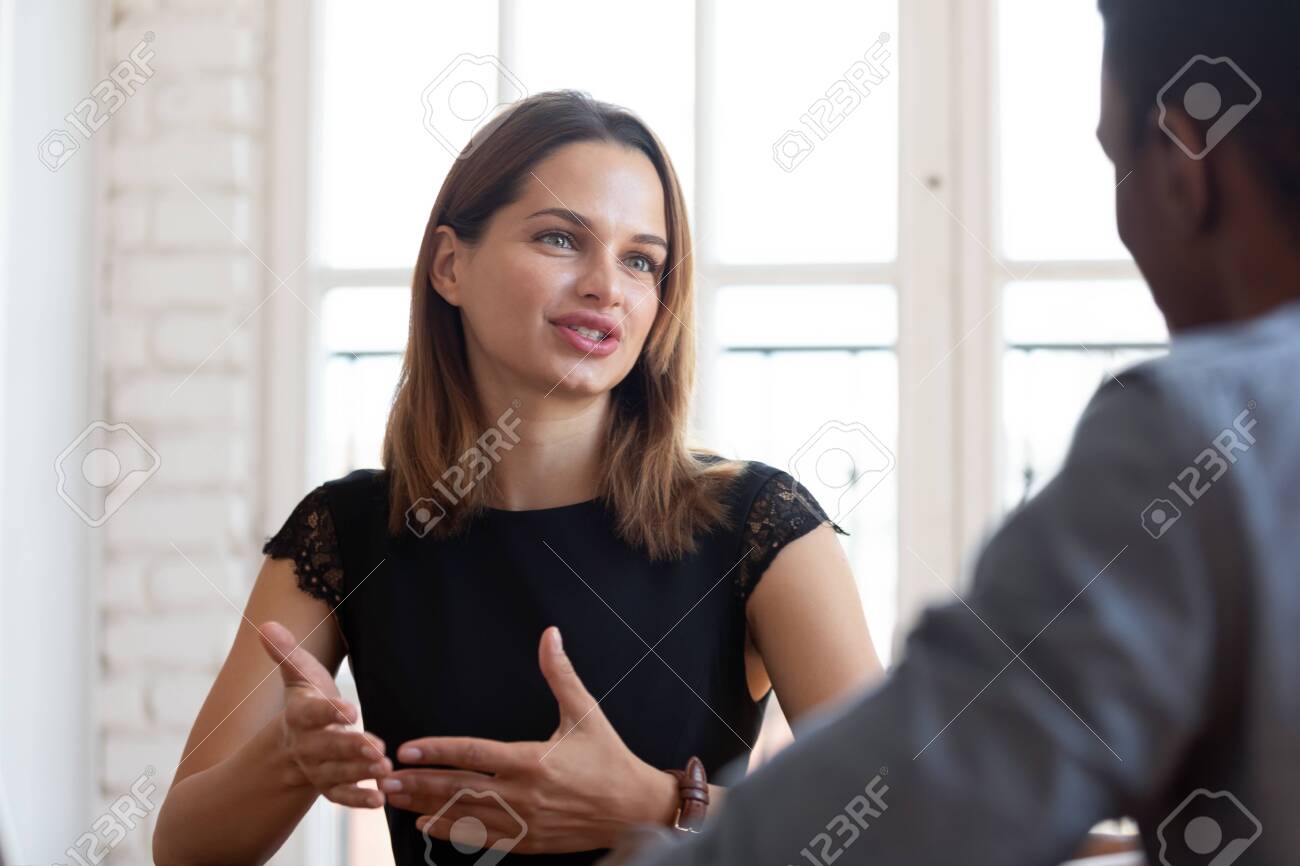 Head shot focus on happy pleasant young female financial advisor realtor lawyer explaining contract details to concentrated thoughtful african american male client at meeting in company office. - 134069158 Head shot focus on happy pleasant young female financial advisor realtor lawyer explaining contract details to concentrated thoughtful african american male client at meeting in company office. - 134069158