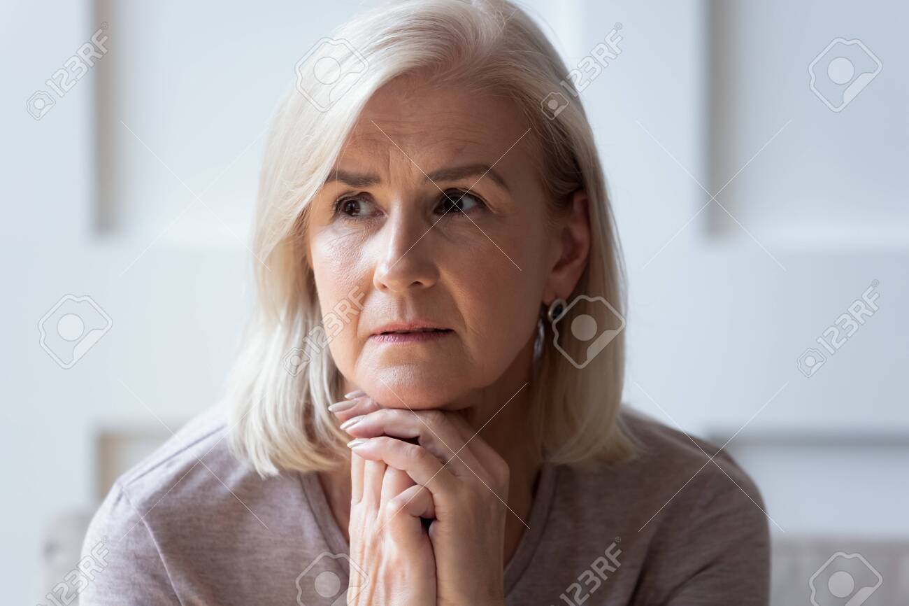 Head shot close up portrait thoughtful middle aged retired woman worrying about personal health problems. Upset older female retiree thinking of family troubles, feeling lonely, sitting at home. - 134207663 Head shot close up portrait thoughtful middle aged retired woman worrying about personal health problems. Upset older female retiree thinking of family troubles, feeling lonely, sitting at home. - 134207663