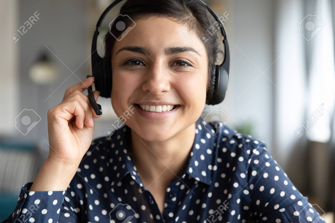Smiling indian girl teacher counselor telesales agent wear wireless headset look at camera webcam, distance teaching, customer support service concept, telemarketing professional closeup portrait - 137224546 Smiling indian girl teacher counselor telesales agent wear wireless headset look at camera webcam, distance teaching, customer support service concept, telemarketing professional closeup portrait - 137224546