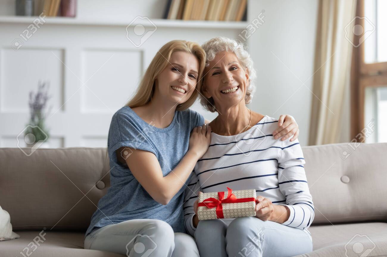 Portrait Of Happy Adult Daughter Greeting Excited Senior Mom
