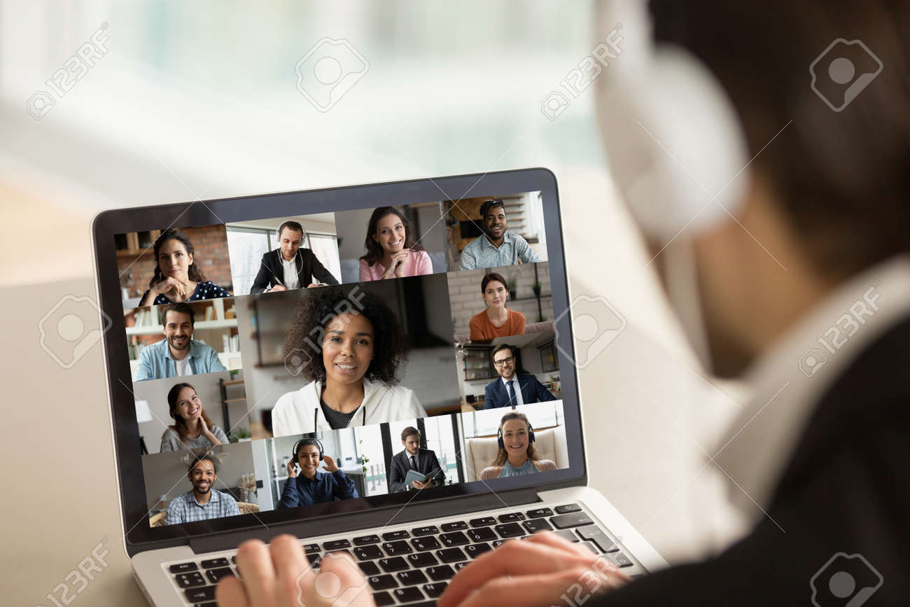 Close up young businessman in headphones holding online video call conference with african american female team leader and diverse colleagues using computer application, distant working communication. - 159071291 Close up young businessman in headphones holding online video call conference with african american female team leader and diverse colleagues using computer application, distant working communication. - 159071291