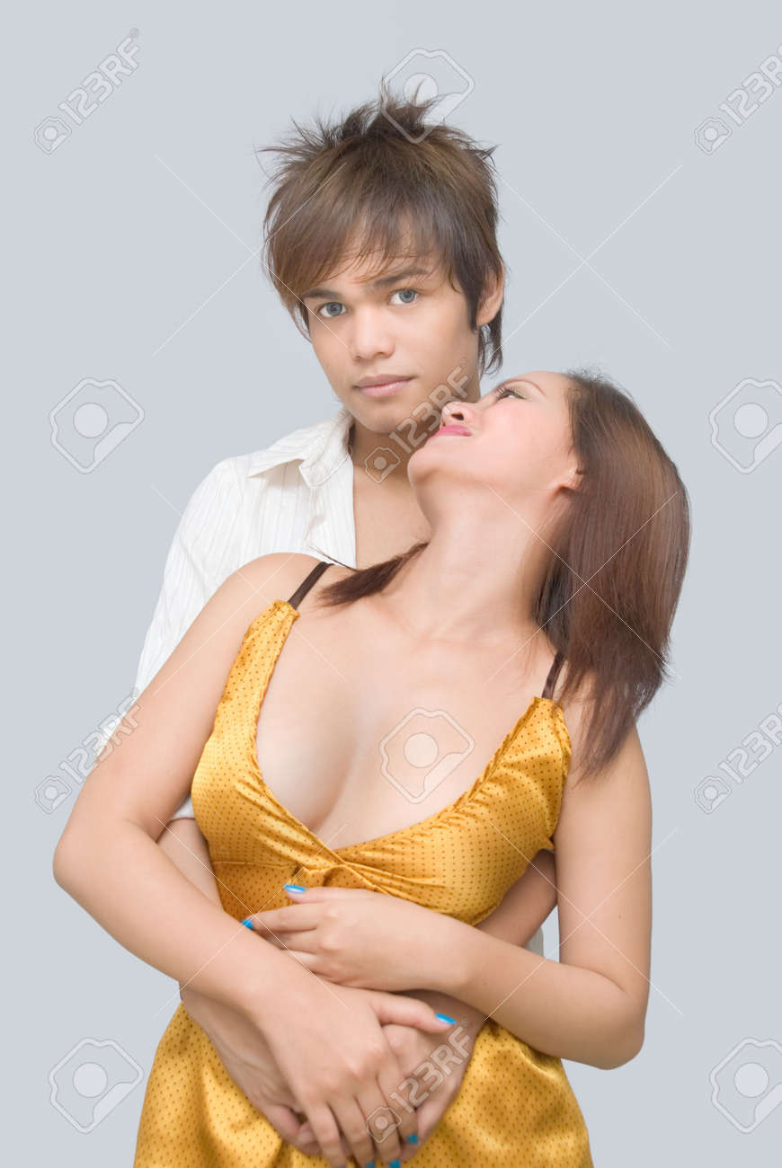 Classy Eighteen Year Old Teenage Couple Dressed For A Formal Dance Party Or  Prom, And Holding Each Other In A Tender Embrace Or Hug While The Girl  Looks Seducing At The Boy.