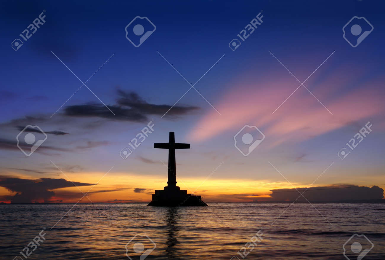 Colorful tropical marine sunset with a large concrete cross silhouette over Sunken Cemetery, Camiguin, Philippines. - 4326508 Colorful tropical marine sunset with a large concrete cross silhouette over Sunken Cemetery, Camiguin, Philippines. - 4326508