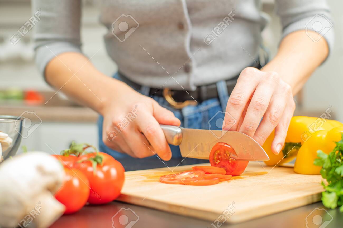 Woman Is Cutting Tomatoes On Cut Board On Kitchen Fresh Vegetables Stock Photo Picture And Royalty Free Image Image 141348520